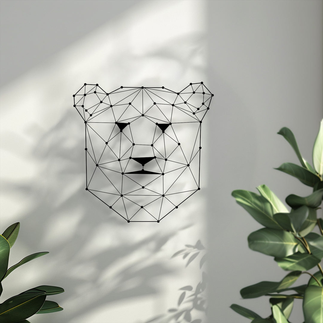 The serene mood of this contemporary geometric bear face unique metal wall art is enhanced by dappled shadows and lush greenery.
