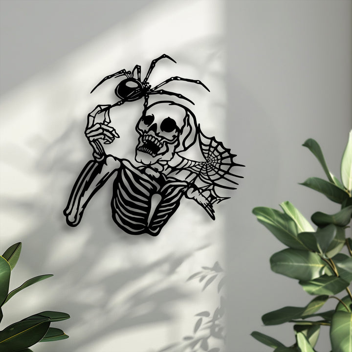 The subtly textured wall surface highlights the smooth, matte black gothic skeleton and spider metal wall decor.