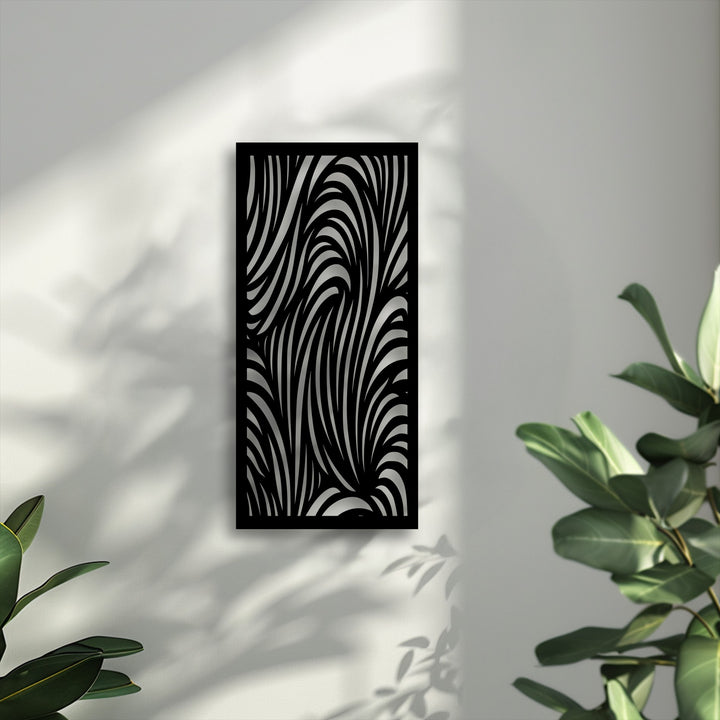 A vertical, black unique metal wall art piece showcases a dynamic, abstract wave pattern, creating an intriguing visual effect on a bright wall.