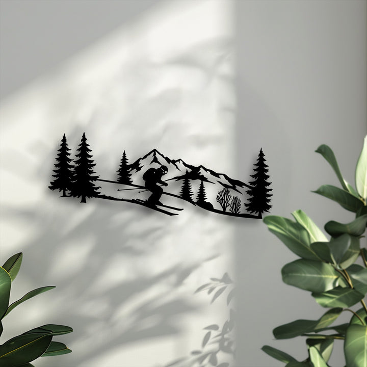 Strong sunlight creates dynamic shadows, emphasizing the detailed black silhouette of the skier mountain metal artwork, flanked by leafy green plants.