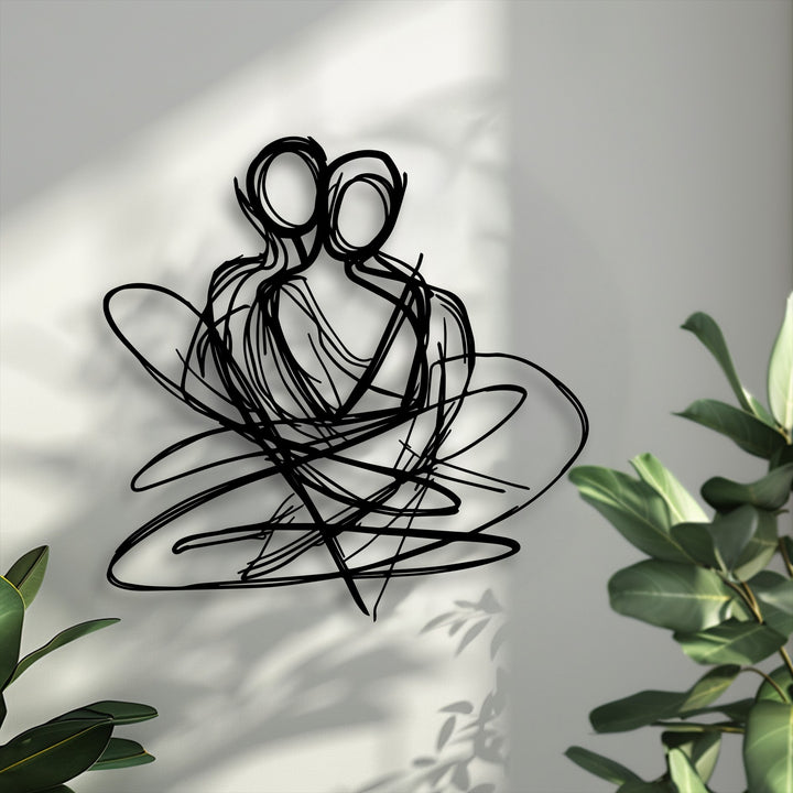 The darkest area prominently features the decorative metal art, showcasing an abstract couple intertwined in a tender embrace.