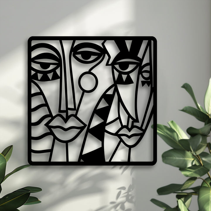 The layered composition of this unique metal wall art depicting abstract cubist faces creates striking depth through its interplay of shadows on the wall.