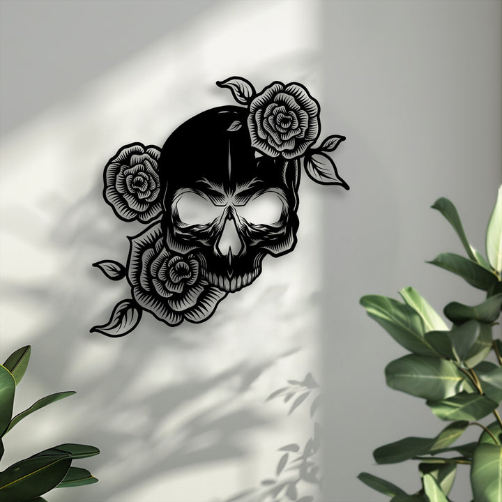 Sunlight casts intricate shadows of a floral skull and leaves onto a bright wall, highlighting this unique metal wall art gothic rose skeleton decor.
