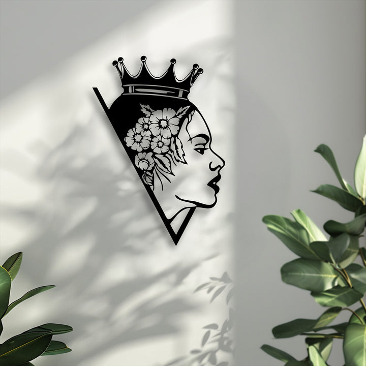 The background shows a subtly textured white wall with soft, natural shadows of leaves, enhancing the elegant woman metal artwork.