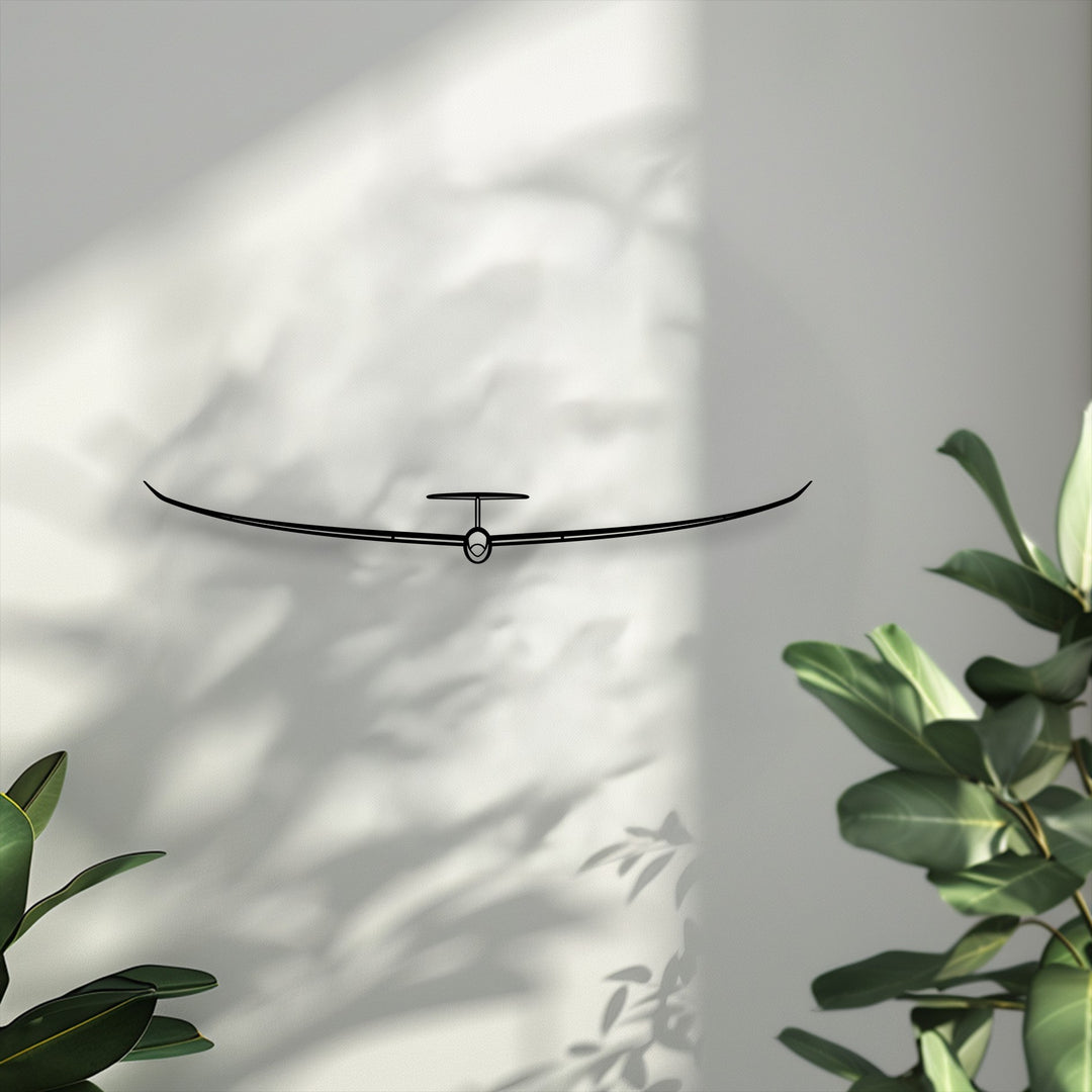 Cool white tones emphasize the sleek minimalist glider metal wall decor amidst soft, dappled light and plant shadows.