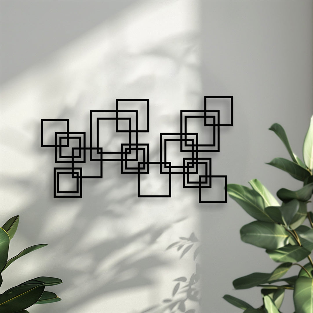 The sleek matte black finish of this unique metal wall art highlights its modern geometric interlocking squares design.