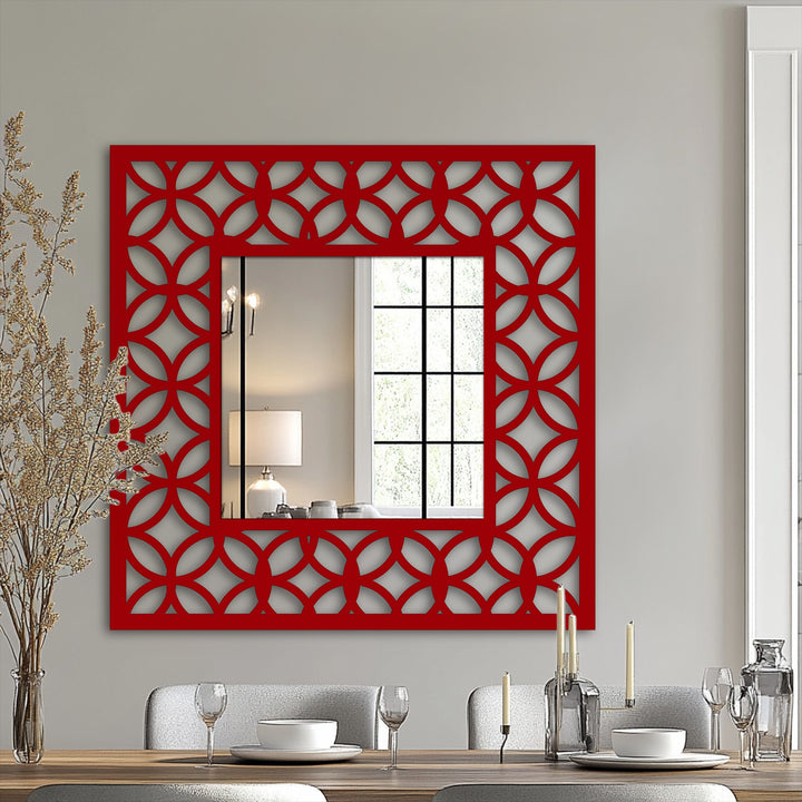 Warm color temperature radiates from the red geometric frame of this decorative mirror, enhancing the interlocking circle pattern in this unique metal wall art design.