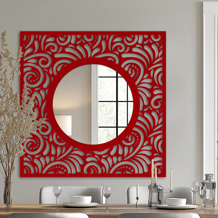 Featuring a vibrant red finish, this ornate decorative metal art mirror showcases an intricately patterned square frame with a striking round center.