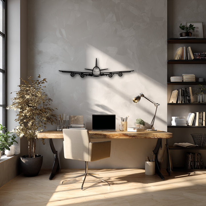 Against a light gray textured wall, a striking black unique metal wall art piece of an airplane front view provides aviation decor.