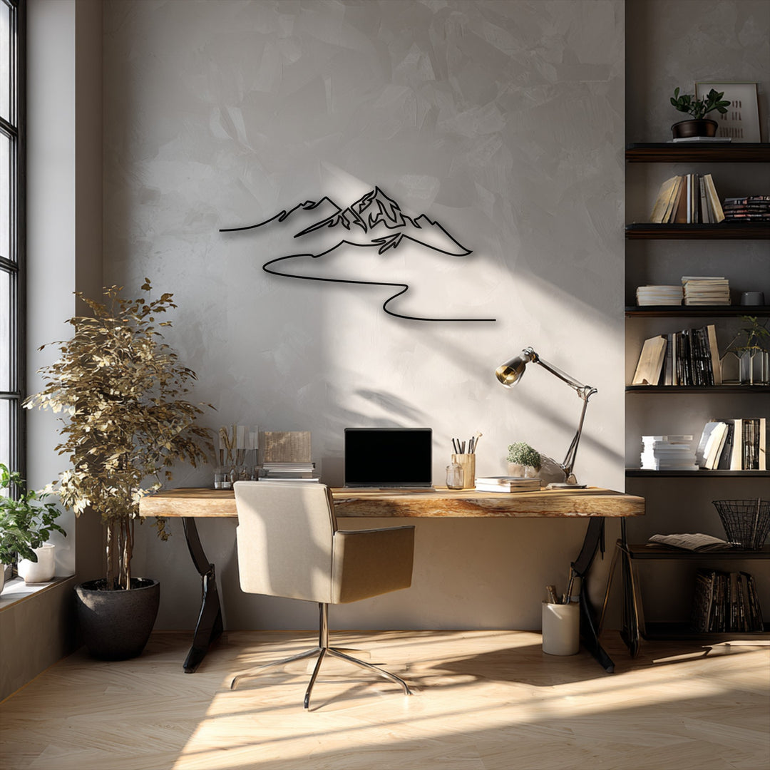 A subtly textured light grey wall forms the background, beautifully highlighting the minimalist mountain decorative metal art under a warm glow.