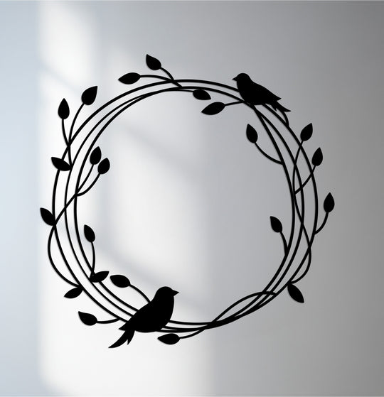 Illuminated by the brightest area, this black metal decoration wall art depicts Whispering Branches, showcasing birds and vines in a round, nature-inspired design.