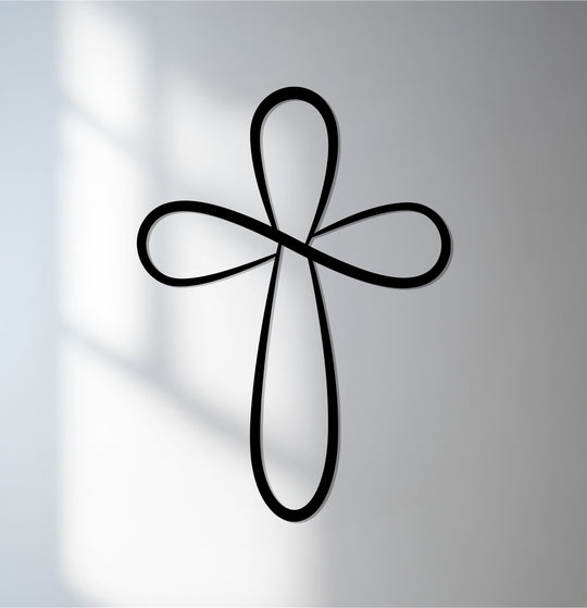 Shadows highlight the metal artwork edges of an Infinite Grace silver loop cross, creating a contrasted look of elegant Christian wall decor.