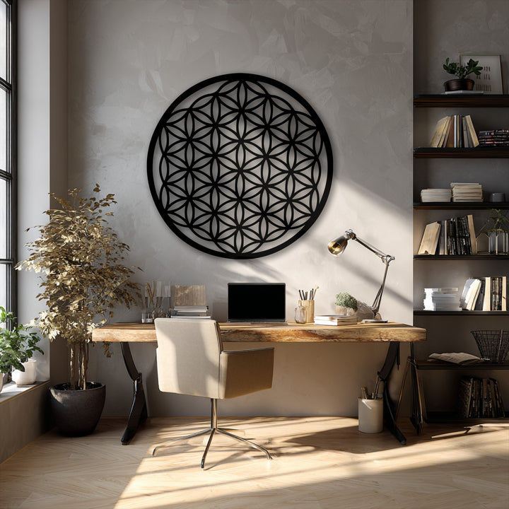 The black Flower of Life metal art for wall, a sacred geometry circle, is the striking focal point above a desk in a modern office.