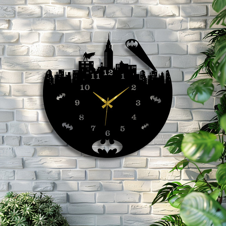 A decorative metal art wall clock vibrantly displays an urban night skyline, where a sweeping Bat-signal beam and perched hero evoke constant movement.