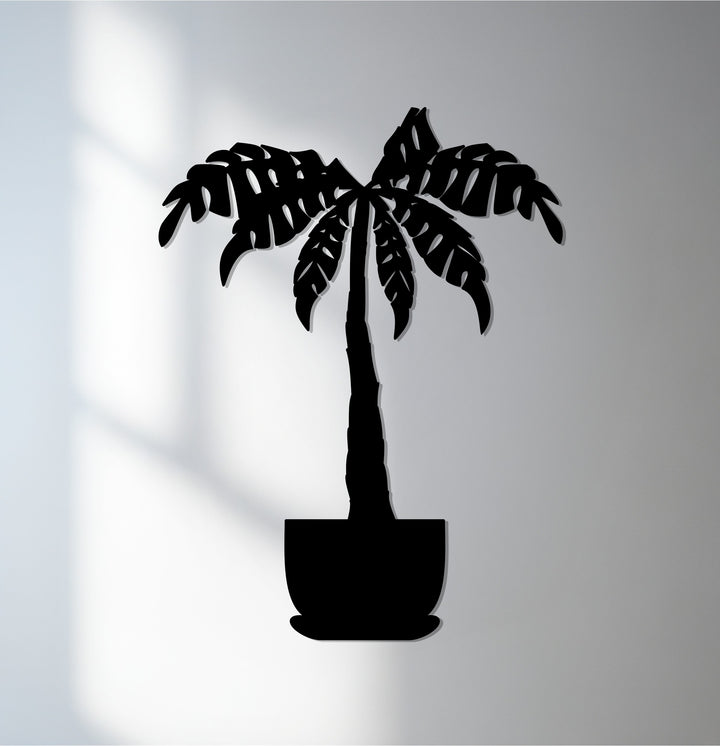 Contrasting shades highlight the sleek, laser-cut edges and smooth, black finish of this tropical palm tree metal art for wall, creating a striking transition between colors.