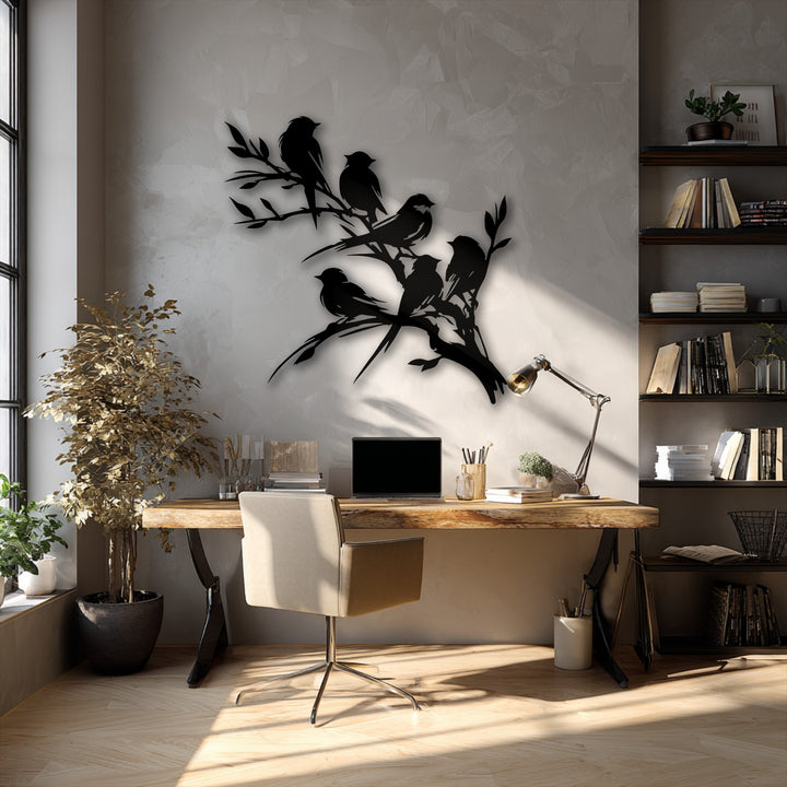 Sunlight brilliantly illuminates a 'Perched Harmony – Birds on Branch' metal wall decor, casting intricate shadows on the wall and floor.