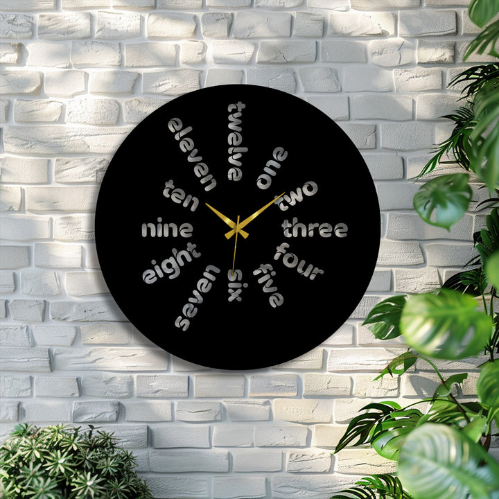 Focusing on the typography, the metal artwork wall clock showcases a modern word-based design with gold hands, adding a contemporary touch to any room.