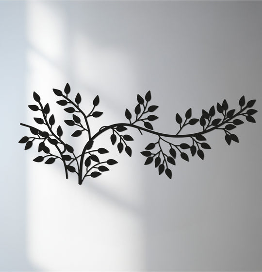 Botanical-inspired metal art for wall showcases the minimalist leaf branch metal wall art design with its stark black silhouette against a softly lit background.