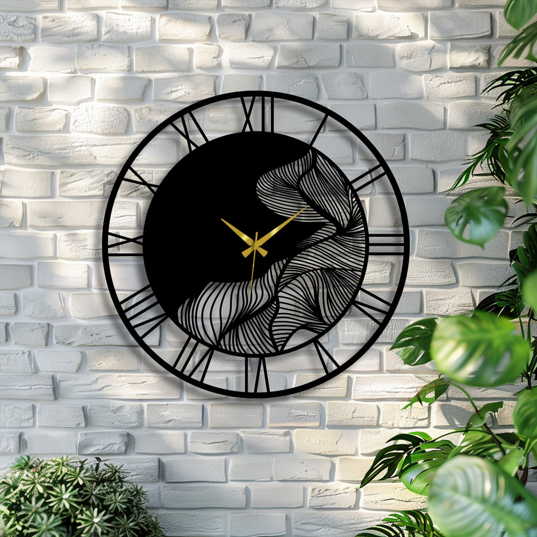 Featuring decorative metal art, a stylish metal wall clock with a leaf design, black frame, gold hands, and Roman numerals boldly stands out against a brick wall.