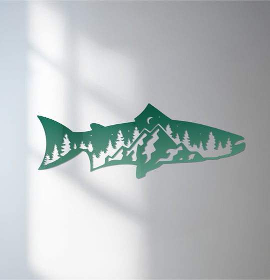 The organic forms of the decorative metal art create a trout silhouette filled with mountain and forest shapes, capturing a serene nature scene.
