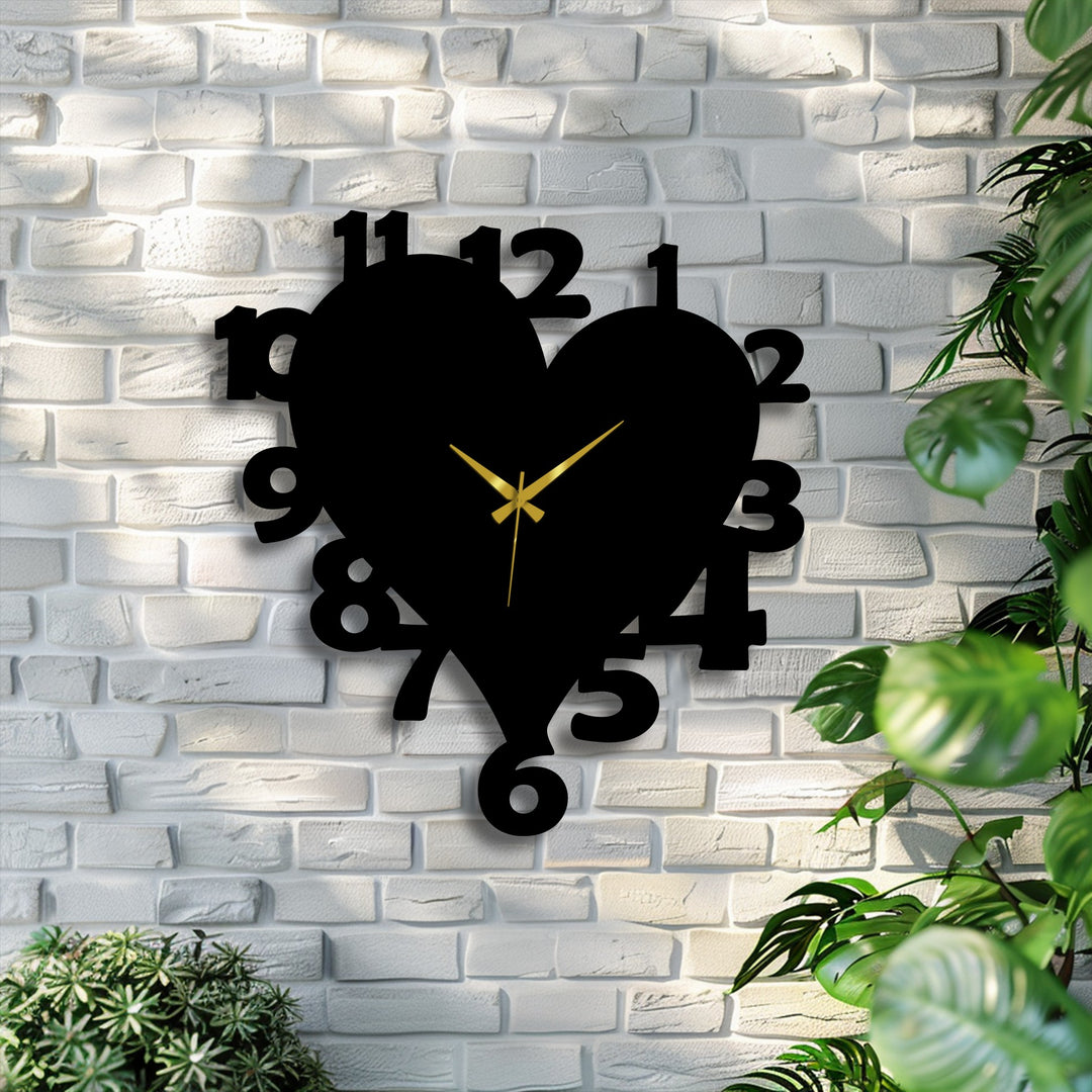 Sharp color contrast defines the black heart shape metal wall clock with gold hands, prominent on a white brick wall, offering striking decoration wall art.