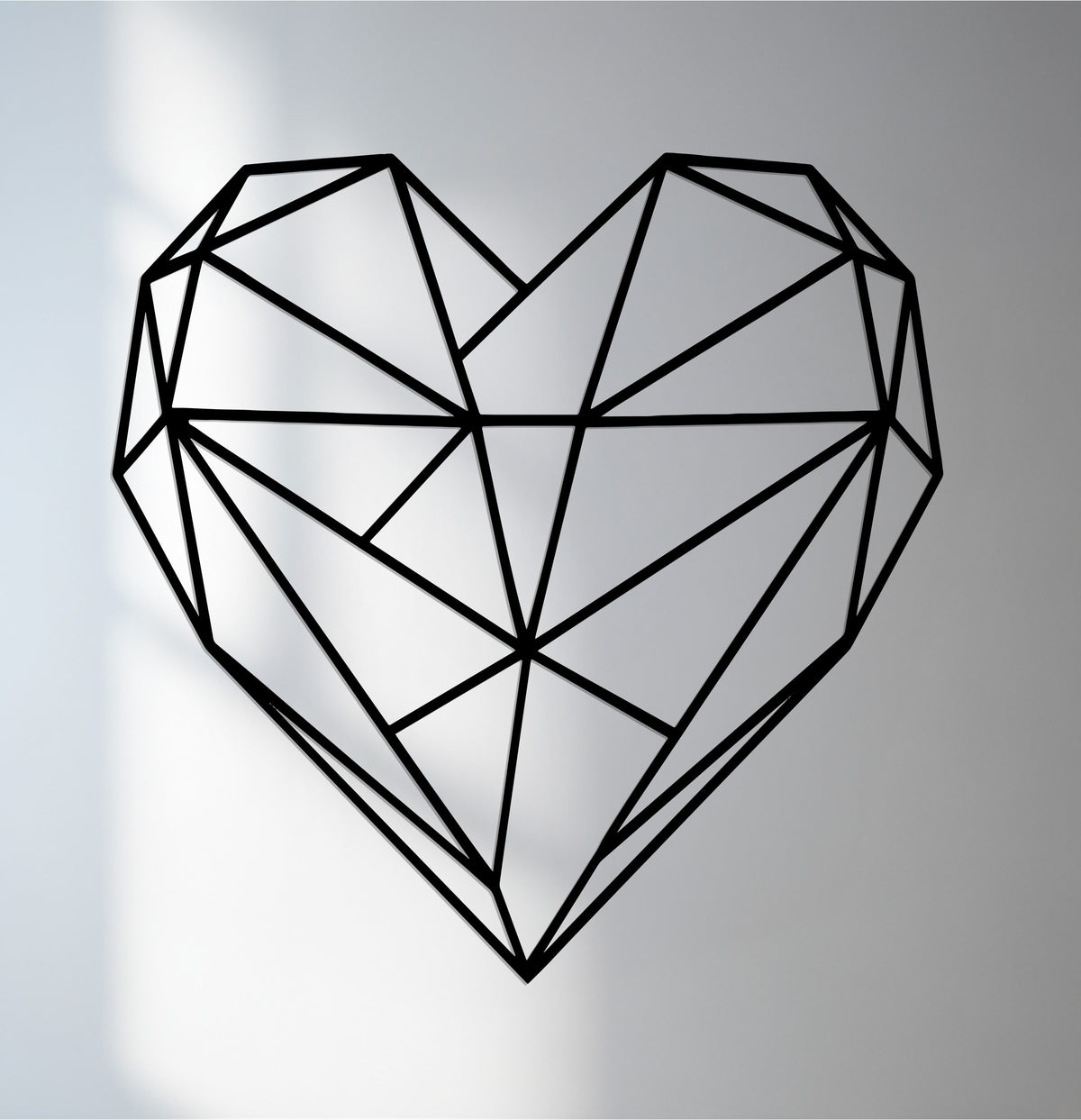Muted color saturation highlights the minimalist form of this decorative metal art geometric heart, creating a modern wall art piece.