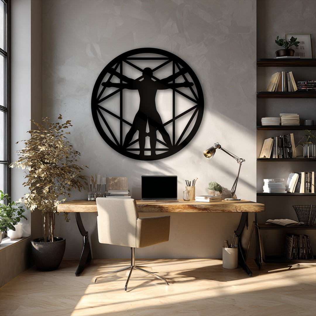The striking black Vitruvian Man geometric circle, a piece of decorative metal art, powerfully commands the textured wall above a rustic wooden desk.