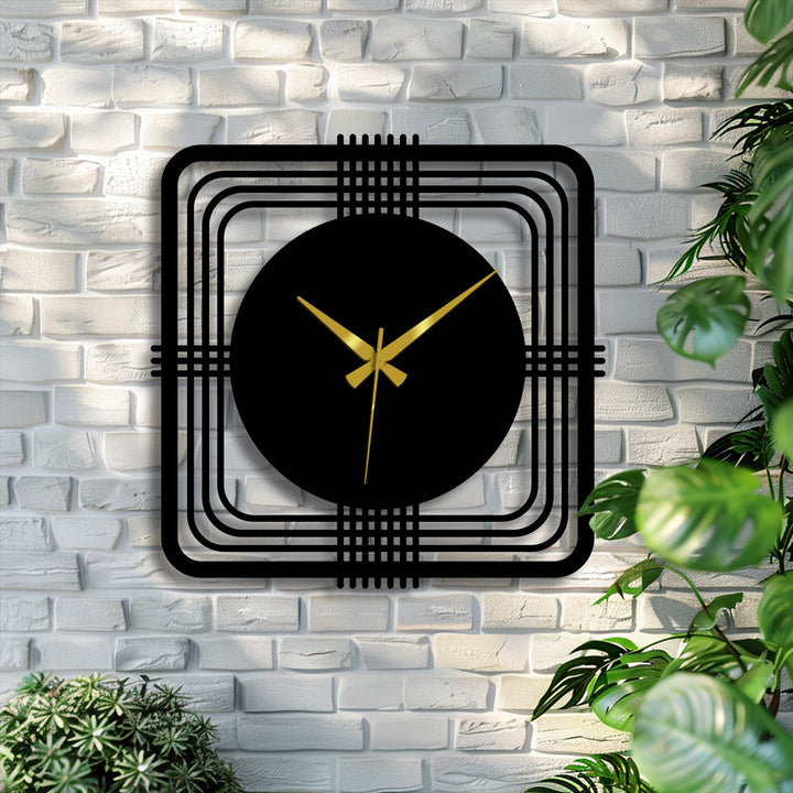 Gleaming gold hands indicate the time on this geometric square frame modern metal wall clock, a piece of unique metal wall art displayed on a brick wall.