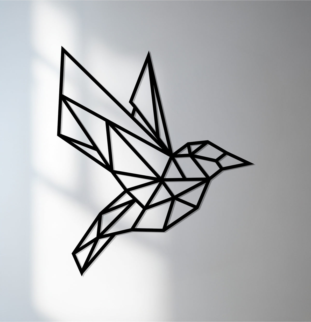 The focal point reveals a black geometric hummingbird decoration wall art, a modern metal piece with a polygon design that creates a captivating focal point.