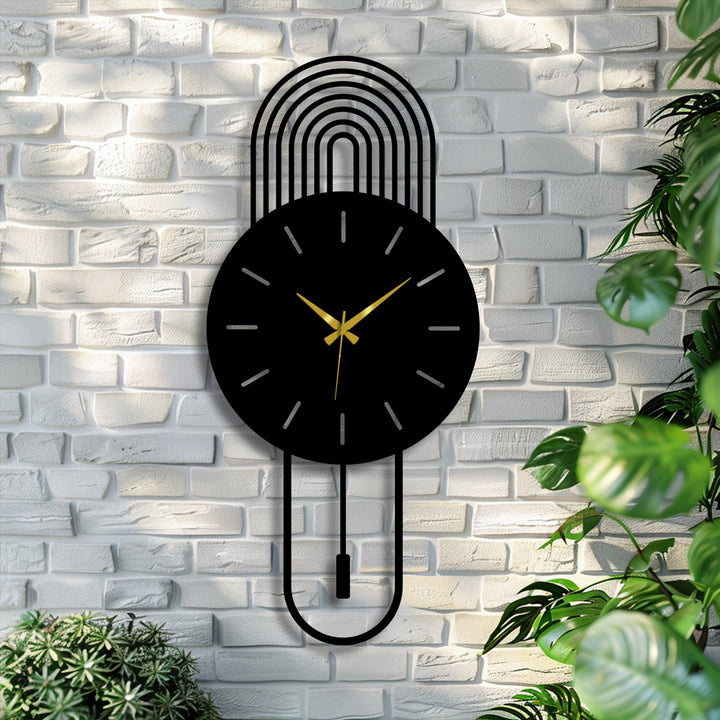 Filtered light softens the black arc metal wall clock, enhancing its pendulum design as a subtle piece of decorative metal art on the textured wall.