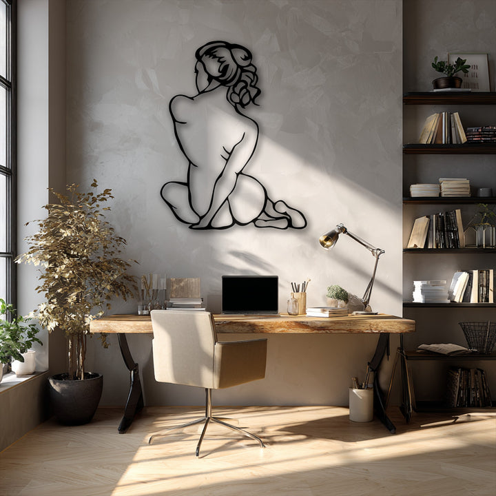 The sleek matte black finish of the Minimal Female Figure metal artwork beautifully contrasts with the textured wall in sunlight.
