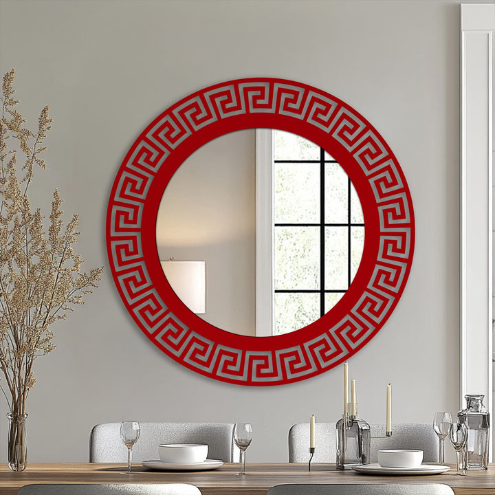 Foreground shows tableware arranged elegantly before a stylish round stained glass wall mirror featuring a striking geometric Greek key design.