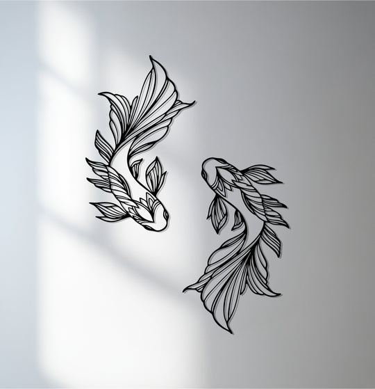 Subtle depth and layers define this decorative metal art depicting two koi fish, with shadows accentuating the linear patterns in the fins and bodies.