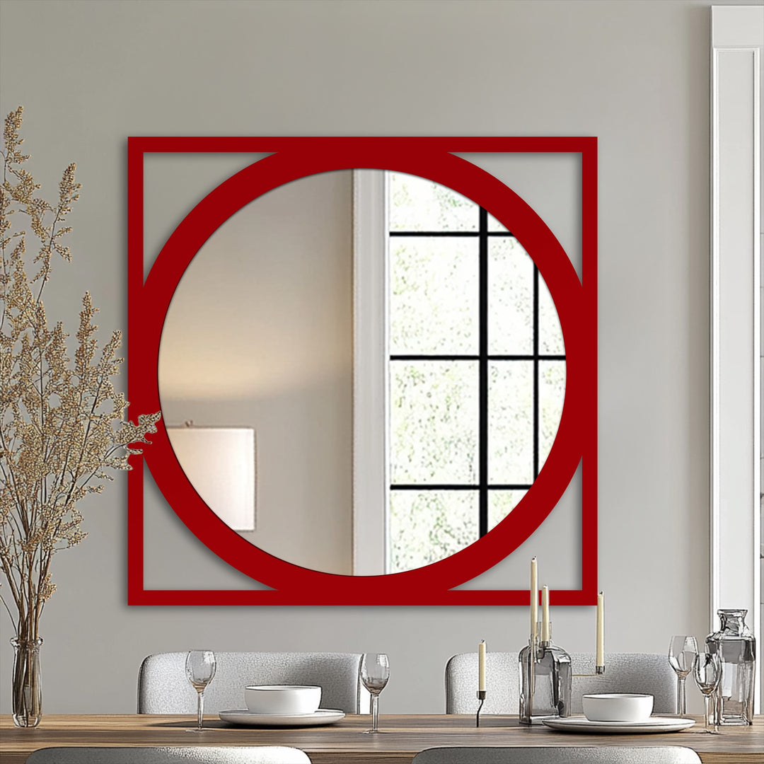 A striking red geometric frame, composed of a square and circle, defines the edge and borders of this modern bathroom mirror.