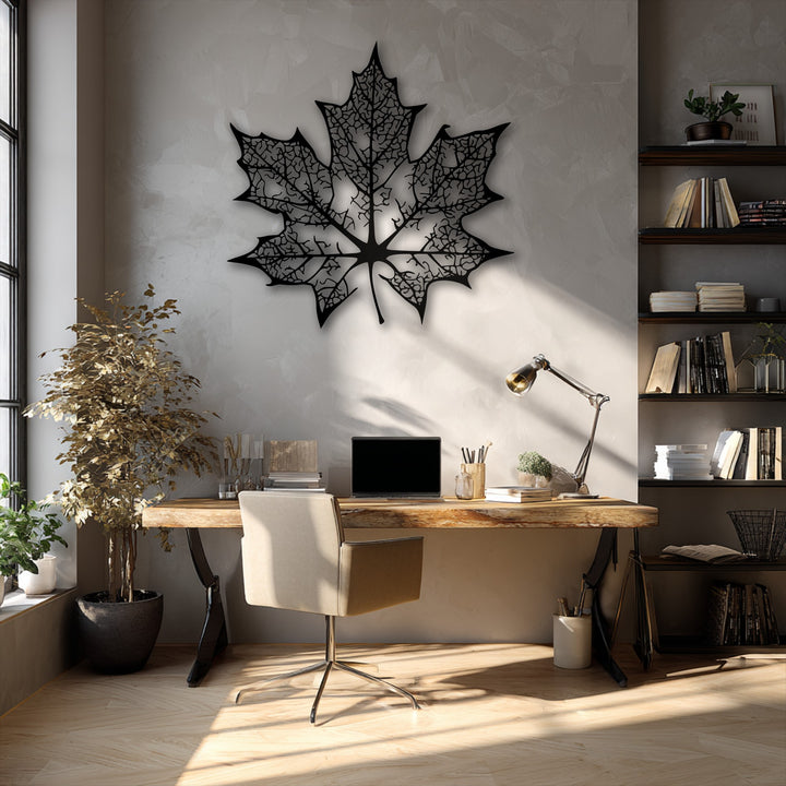 The darkest area showcases an intricate black maple leaf metal wall decor, its detailed silhouette creating a striking contrast on a textured wall.