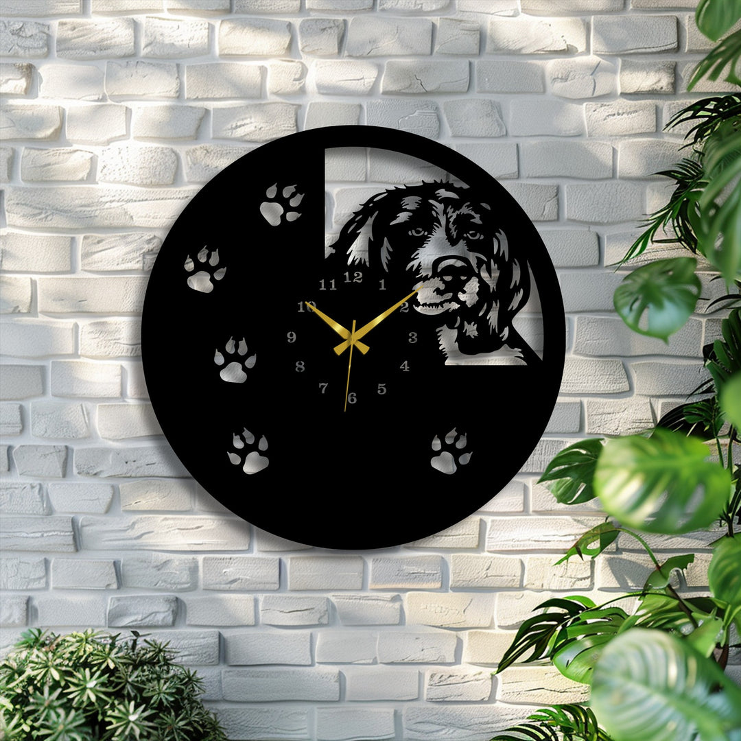 The sleek, matte black finish of this unique metal wall art clock features a distinctive laser-cut dog silhouette and paw print design.