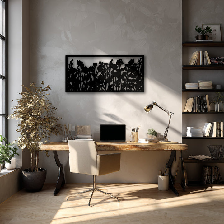The brightest area, illuminated by sunlight on a wooden floor and desk, highlights a striking wildflower silhouette metal wall decor.