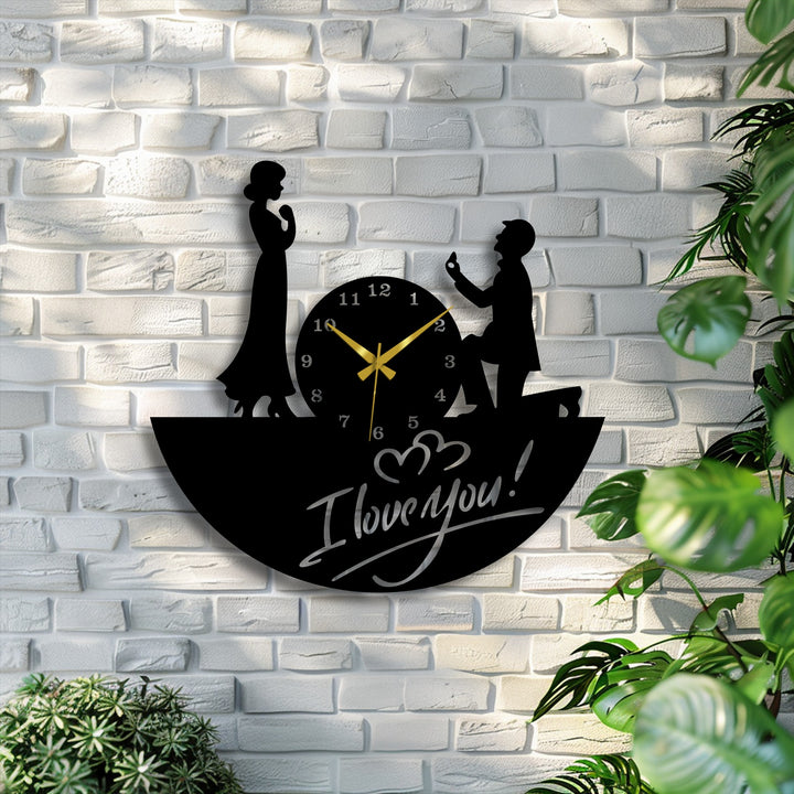Implied motion animates the Love Proposal Metal Wall Clock, where a kneeling figure and 'I Love You' script suggest anticipation within the metal art for wall.