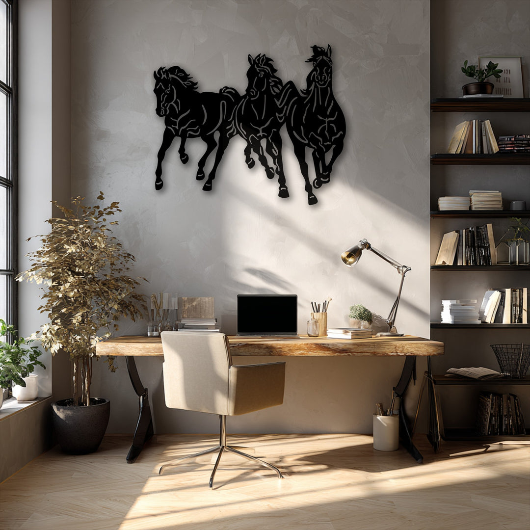 Delicate, dried leaves of a tall plant gently catch the sun's soft light next to a bold galloping trio horses metal wall decor piece.