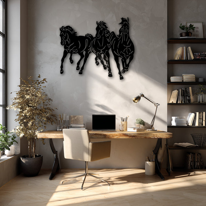 Delicate, dried leaves of a tall plant gently catch the sun's soft light next to a bold galloping trio horses metal wall decor piece.