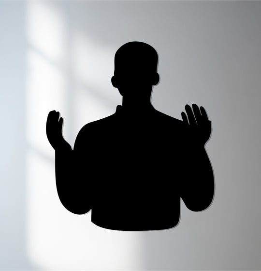 Silhouette of a person with their hands raised in prayer, showcasing the unique metal wall art that embodies Islamic faith and devotion.