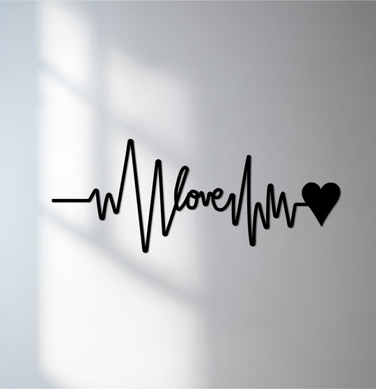 Subtle shadows play across the plain background, highlighting the minimalist Eternal Pulse Love heartbeat design as metal artwork.