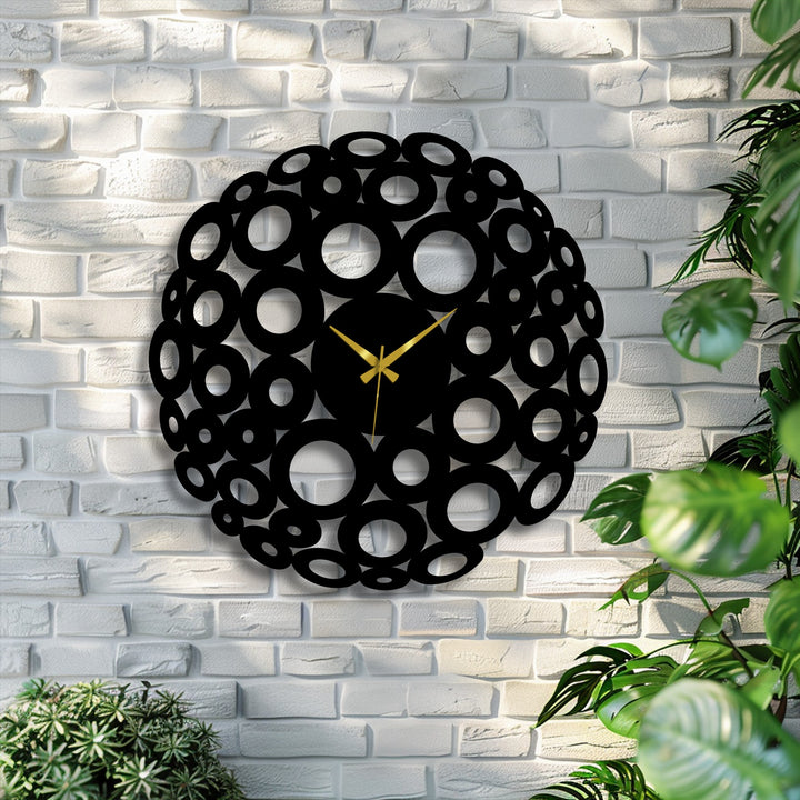 The ornate edge and borders of this black bubble circle metal wall clock, designed with an abstract ring of cutouts, showcase chic metal wall decor.