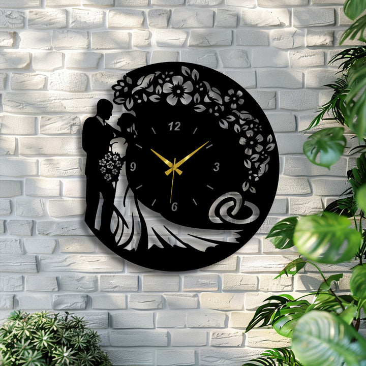The focal point showcases an intricate black metal artwork wedding wall clock, featuring a loving bride and groom silhouette with floral and ring details.
