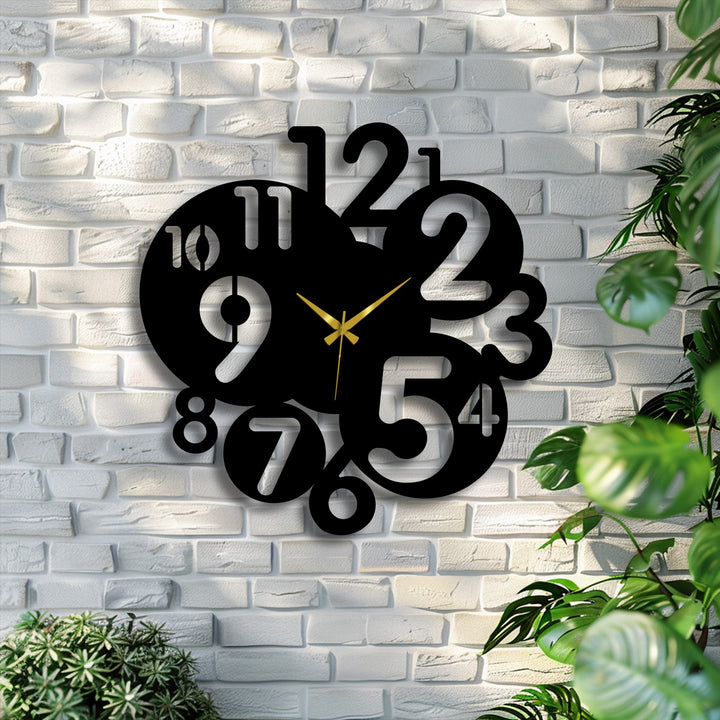 Bold black metal art for wall features a modern abstract number clock with gold hands against a bright white brick wall.