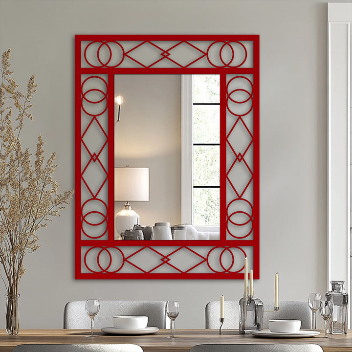 Light and shadow play across the red frame of this metal wall art mirror, highlighting the geometric decoration wall art and the reflective surface within.
