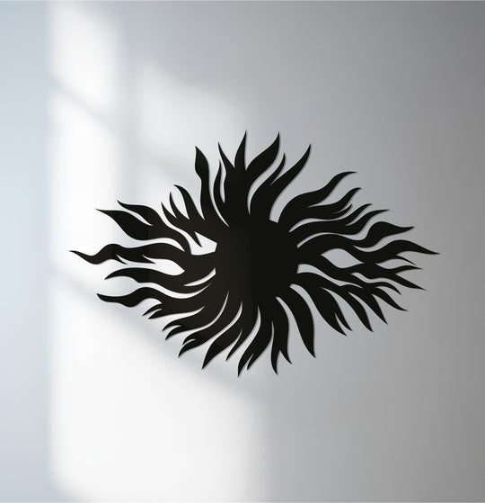Striking light and shadow emphasize the intricate details of this sunburst metal art for wall, enhancing its radiant, abstract flame design.