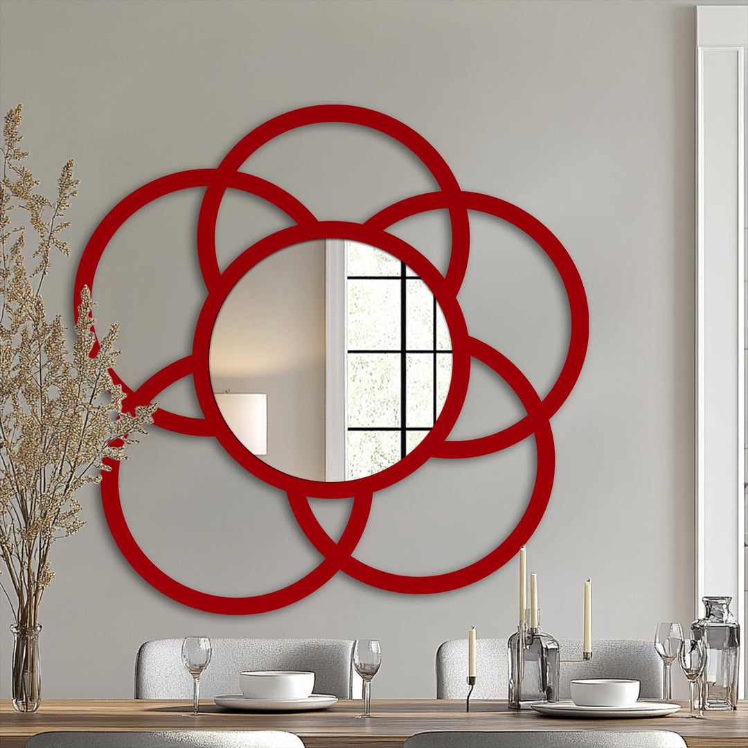 The glossy red finish highlights the modern interlock circle mirror's decorative metal art frame, reflecting light and adding a striking visual element.