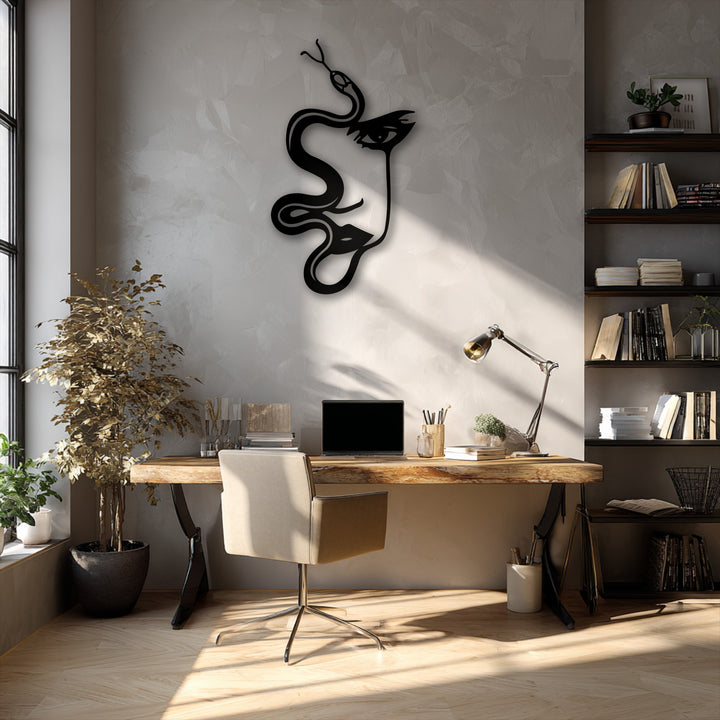 The image features a workspace with subdued color saturation, highlighting the unique metal wall art of an abstract woman and serpent silhouette.