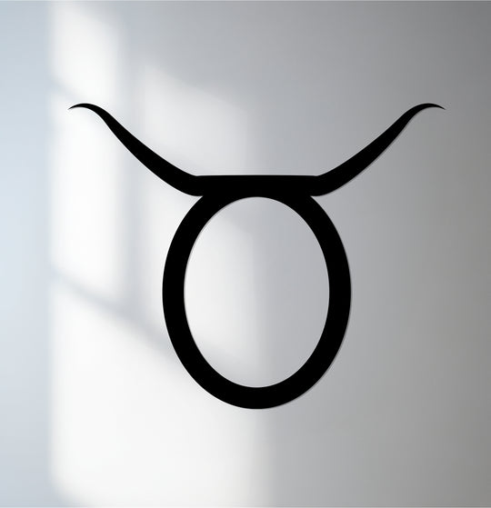 Bold, black Taurus astrology symbol stands out as a striking piece of metal artwork against the muted backdrop.